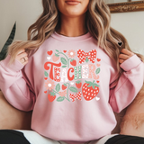Person wearing a pink sweatshirt with 'TEACH' and strawberry design.