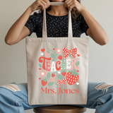 Person holding a tote bag with 'Teacher Mrs. Jones' design