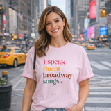 Woman wearing a pink t-shirt with colorful text in an urban setting