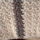 Close up hand crocheted ivory and gray striped blanket