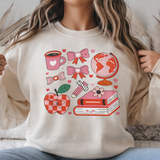 Person wearing a cream-colored sweatshirt with colorful graphics, sitting on a couch.