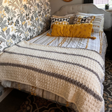 Bedroom with floral headboard, patterned bedding, and decorative pillows.