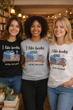 Three women wearing t-shirts with a book-themed design in a bookstore.