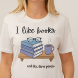 Person wearing a white t-shirt with 'I like books and like, three people' design.