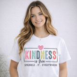 Woman wearing a white t-shirt with a colorful 'Kindness is free' design.