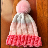 Knitted hat with pink and white pattern on a wooden floor