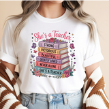 Person wearing a white t-shirt with colorful text and book design, sitting on a beige background.