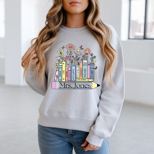 Person wearing a gray sweatshirt with colorful book design and text.