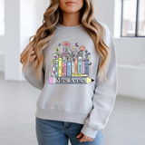 Person wearing a gray sweatshirt with colorful book design and text.